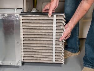 man changing a folded dirty air filter